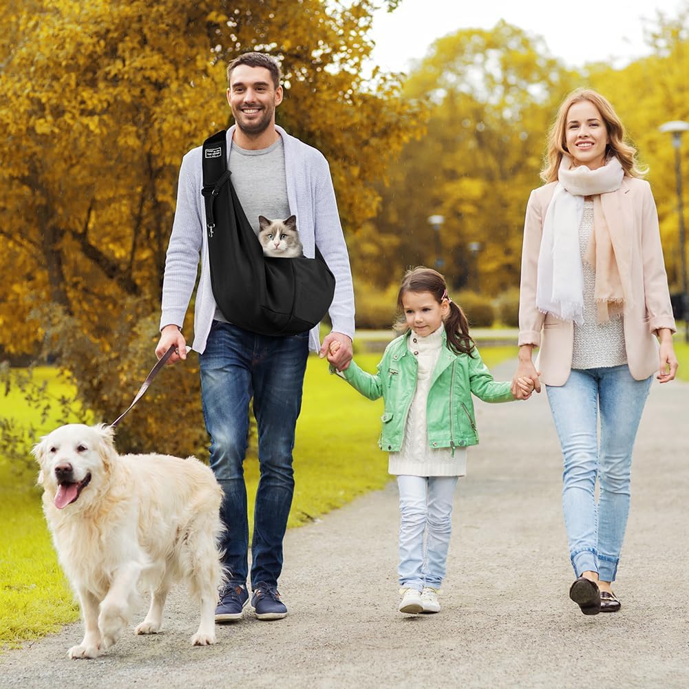 Man carrying a cat in a black pet sling on a family walk